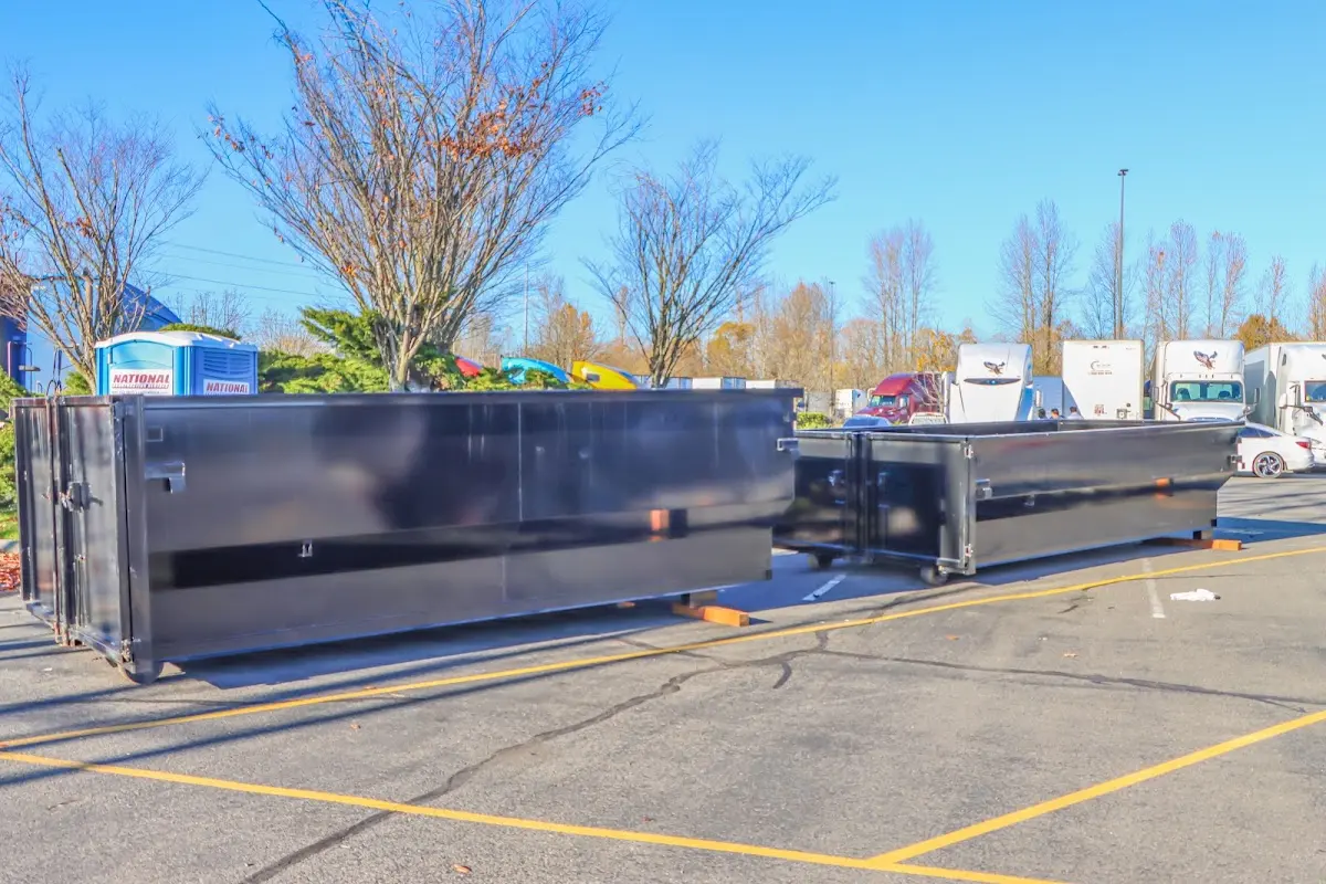 Professional dumpster rental service with roll-off container on residential driveway in McKees Rocks